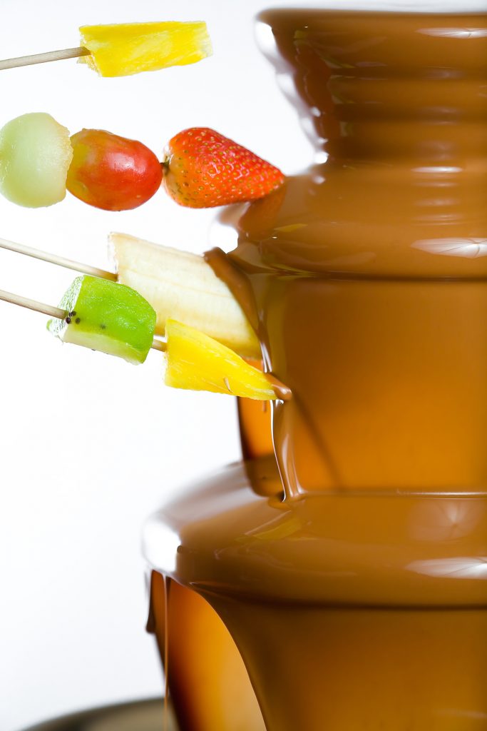Dipping fruits into a Chocolate Fountain